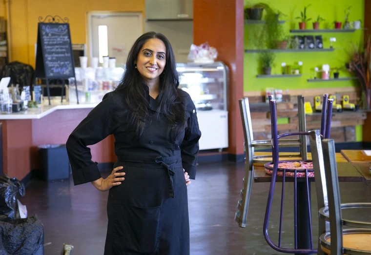 a woman standing in black chef's uniform 