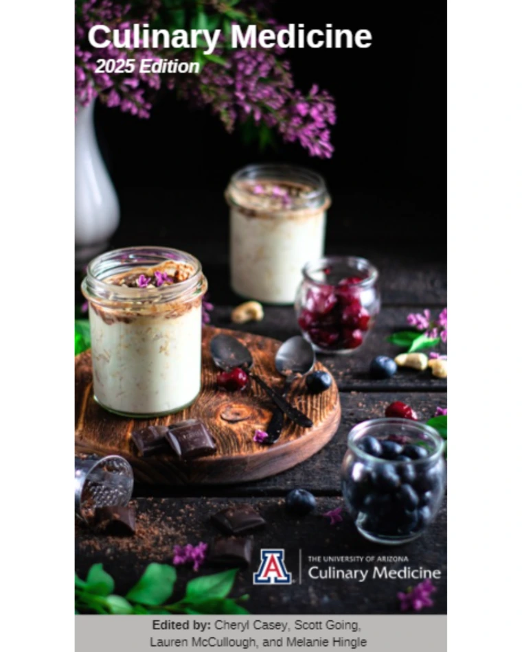 Mason jars with porridge on a black background with flowers, blueberries, mint, and shaved dark chocolate